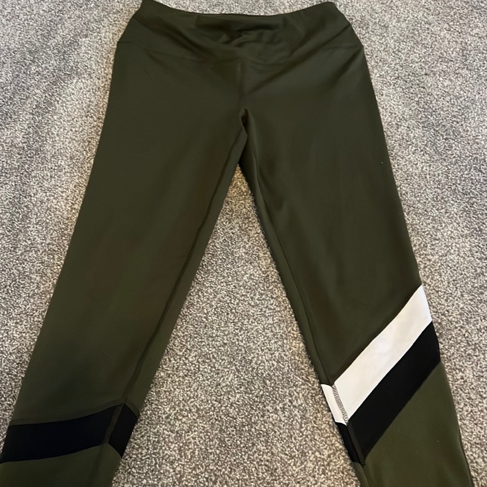 Green athletic leggings with design in the bottom front